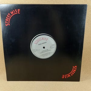 May include: A black vinyl record album cover with the text "STREET WISE" in red at the top left and bottom right corners. The record label in the center reads "NEW ORDER" and "CONFUSION CONFUSION BEATS".