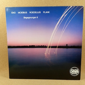 May include: A vinyl record album cover with a pink and blue sunset over a lake. The album is titled "Begegnungen II" by Eno, Moebius, Roedelius, and Plank. The album cover features a Direct Metal Mastering logo.