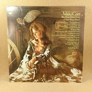 May include: A vintage vinyl record album cover featuring a portrait of Vikki Carr, a singer, in a brown and white patterned dress. The album title is "The First Time Ever (I Saw Your Face)" and lists the songs included on the record.