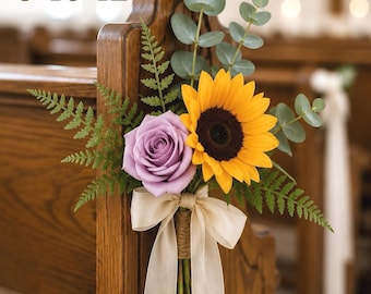 Könnte beinhalten: Ein Blumenarrangement mit einer lavendelfarbenen Rose, einer leuchtend gelben Sonnenblume, grünen Farnwedeln und Eukalyptuszweigen. Die Stiele sind mit Schnur umwickelt und mit einem langen beigen Band gebunden. Der Text lautet: Sold in sets 6-10-12.