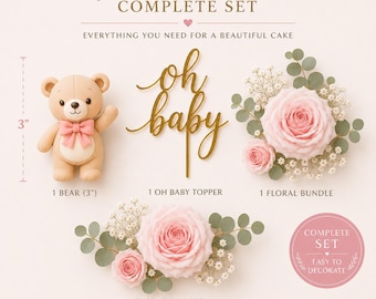 Könnte beinhalten: Ein Tortendekorationsset bestehend aus einem 7,6 cm großen beigen Bären mit rosa Schleife, einem goldenen Tortenstecker mit der Aufschrift oh baby und zwei Blumenarrangements aus hellrosa Rosen, weißem Schleierkraut und Eukalyptusblättern.