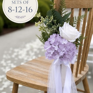 Könnte beinhalten: Ein Holzstuhl, geschmückt mit einem Blumenarrangement aus einer weißen Rose, hellvioletten Hortensienblüten und grünem Blattwerk. Ein weißes Satinband und Tüllstoff hängen herab. Der Text auf dem Bild lautet: SOLD IN SETS OF 8-12-16.