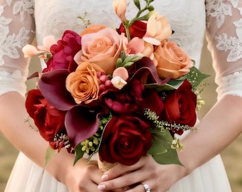 Könnte beinhalten: Ein Blumenstrauß mit dunkelroten Rosen, dunkelburgunderfarbenen Calla-Lilien und zart pfirsichfarbenen Rosen. Das Arrangement enthält kleine grüne Zweige und helle Knospen, die zu einem Bündel mit sichtbaren Stielen an der Basis zusammengefasst sind.