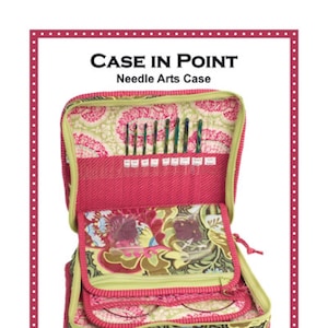 May include: A pink and green fabric needle arts case with multiple pockets and compartments. The case is open to reveal a variety of needles and tools. The case is labeled "CASE IN POINT Needle Arts Case".