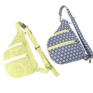 May include: Two sling bags with adjustable straps. One bag is green with a white floral pattern and the other is blue with a white star pattern.