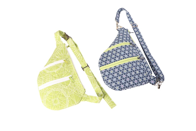 May include: Two sling bags with adjustable straps. One bag is green with a white floral pattern and the other is blue with a white star pattern.