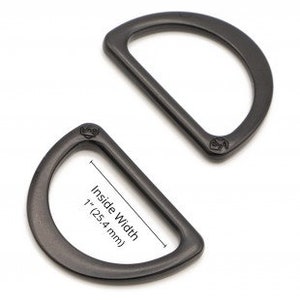 Puede incluir: Dos anillos en D de metal negro, uno con un ancho interior de 2,5 cm.