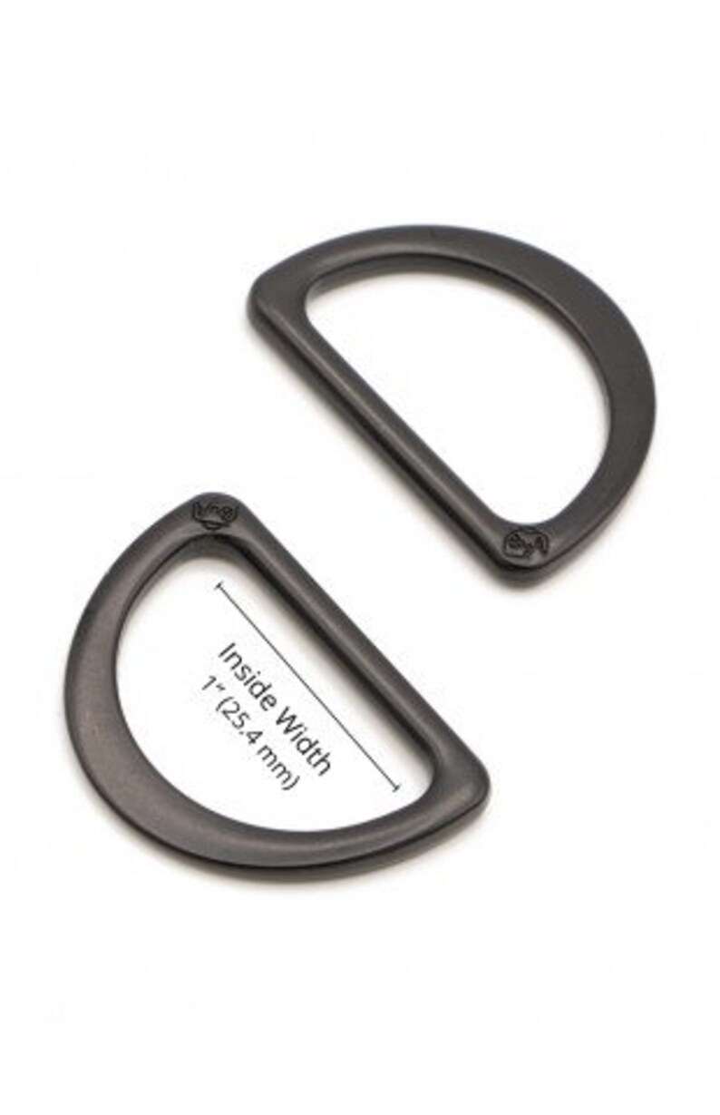 Puede incluir: Dos anillos en D de metal negro, uno con un ancho interior de 2,5 cm.
