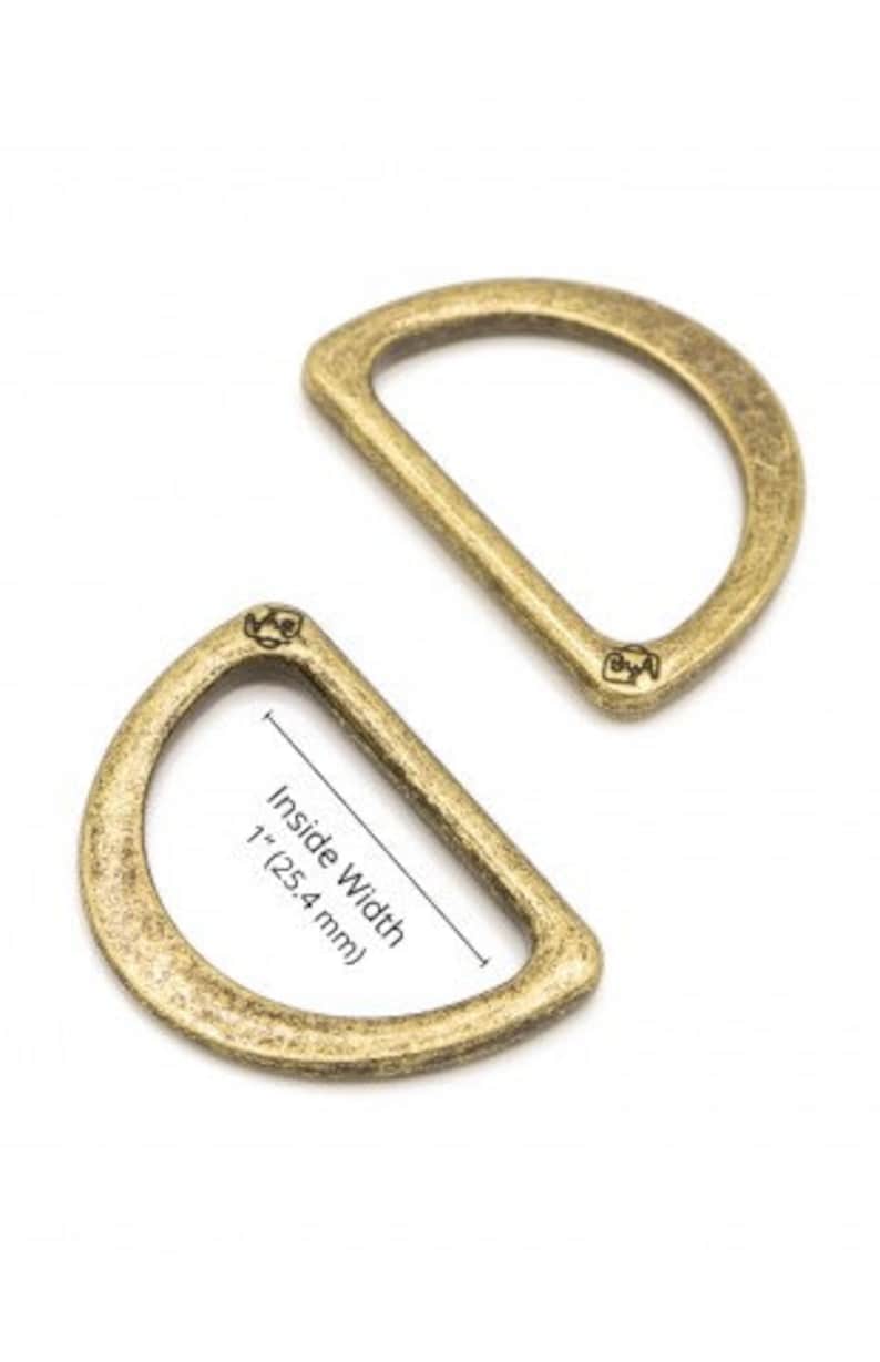 Puede incluir: Dos anillos en D de metal de color dorado antiguo. El anillo m&aacute;s grande tiene un ancho interior de 1 pulgada (2,54 cm).