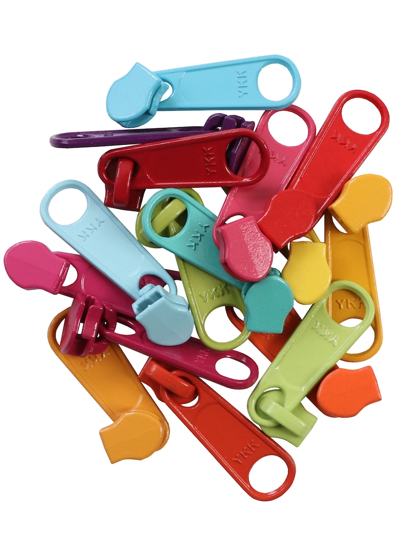 May include: A pile of colorful plastic zipper pulls with the YKK logo. The pulls are in various colors, including red, orange, yellow, green, blue, and purple.