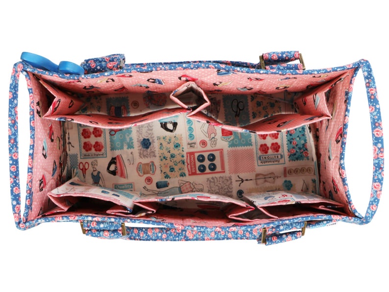 May include: A blue and pink fabric tote bag with multiple compartments and two handles. The bag is lined with a pink fabric and has a floral print.