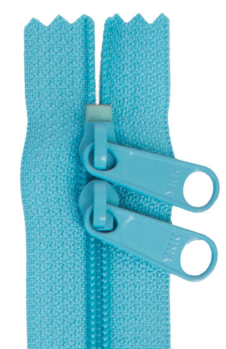 May include: A close-up of a light blue zipper with two pull tabs. The zipper is made of a woven fabric and has a smooth finish.
