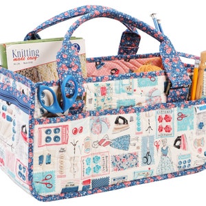May include: A blue and white fabric tote bag with multiple pockets and compartments. The bag has a floral pattern and features a variety of sewing-themed images, including buttons, scissors, and an iron. The bag is filled with various sewing supplies, including yarn, needles, and scissors.