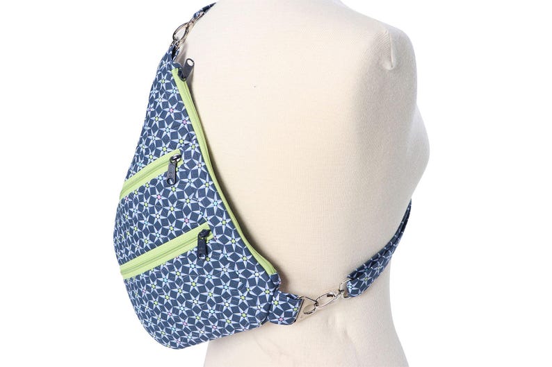 May include: A blue and green patterned crossbody bag with a zippered pocket and adjustable strap.