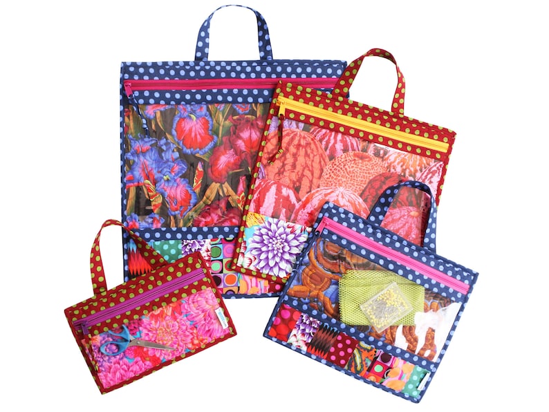 Puede incluir: Cuatro bolsas con cremallera con paneles de vinilo transparentes y dise&ntilde;os de tela floral de colores. Las bolsas est&aacute;n hechas de tela azul con lunares blancos y tienen cremalleras rosas. Las bolsas tienen asas y est&aacute;n anidadas unas dentro de otras.