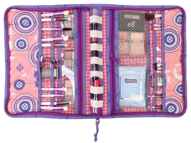 May include: Purple and pink zippered makeup bag with multiple compartments and elastic loops for holding brushes, palettes, and other makeup items. The bag is open and shows the contents, including brushes, eyeshadow palettes, and a small bottle of lotion.