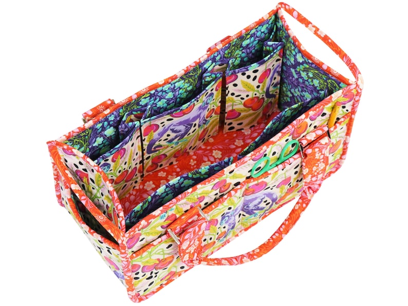 May include: A colourful fabric tote bag with multiple pockets and a zipper closure. The bag is lined with a floral print fabric and has a cherry pattern on the outside.