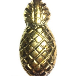 Puede incluir: Un pomo de puerta en forma de piña de color dorado.