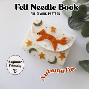 May include: A white felt needle book with an orange fox design, stars, and crescent moons. The text "Felt Needle Book PDF Sewing Pattern" is at the top. The words "Beginner Friendly" are in a circle, and "Autumn Fox" is written in orange.