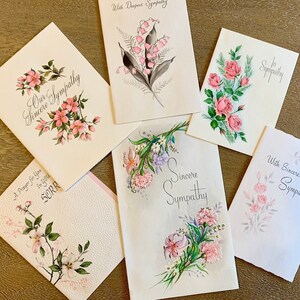 May include: Five sympathy cards with floral designs and the words "Our Sincere Sympathy", "With Deepest Sympathy", "In Sympathy", "Sincere Sympathy", and "With Sincere Sympathy".