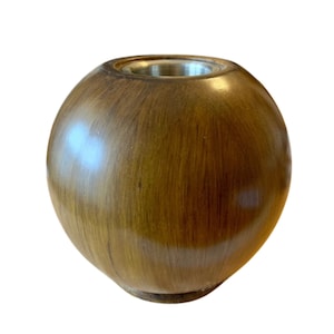 May include: A round wooden incense burner with a metal top. The burner is a dark brown color and has a smooth, polished finish.