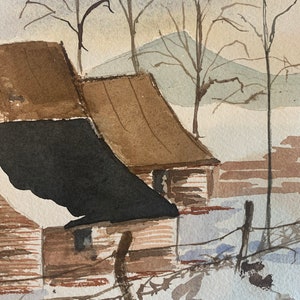 May include: Watercolor painting of a winter landscape featuring two rustic buildings with brown roofs and a black roof. Bare trees and a snow-covered ground are visible, with a soft blue and tan sky in the background. A fence runs along the bottom.