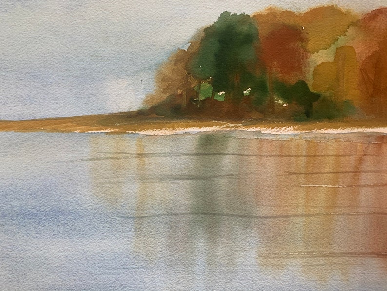 May include: Watercolor painting of a serene landscape featuring a body of water reflecting the sky and the colors of the trees on the shore. The trees display shades of green, brown, and yellow, suggesting an autumn scene.