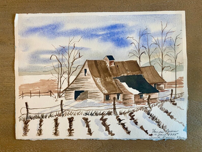 May include: Watercolor painting of a barn in a winter landscape. The barn has a brown roof and white walls, with snow on the ground and a blue sky. Bare trees and a fence are also visible. The painting is signed and dated.