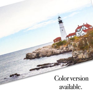 May include: A white lighthouse with a black roof stands on a rocky cliff overlooking the ocean. The lighthouse is surrounded by green trees and bushes. The sky is blue and cloudy.