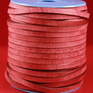 May include: A spool of red leather cord, wound tightly and ready for crafting projects.