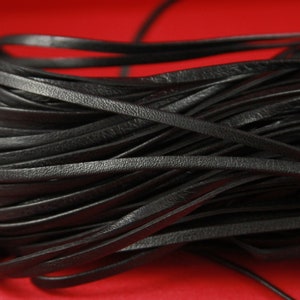 Peut inclure: Un gros plan d'un paquet de cordon en cuir noir. Le cordon est lisse et souple, et il est parfait pour les projets d'artisanat.