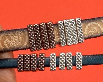 May include: Two leather bracelets with metal bead accents. One bracelet is dark blue with copper-colored beads and silver-colored beads. The other bracelet is brown with copper-colored and silver-colored beads.