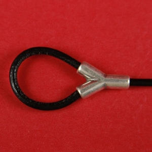 May include: A black leather cord with a silver Y-shaped connector. The connector has two openings for the cord to pass through.