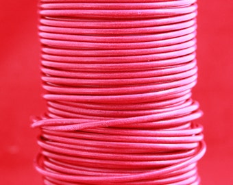 May include: A close-up of a spool of bright pink leather cord. The cord is wound tightly around the spool, creating a smooth, even surface.