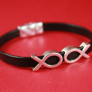 May include: A black leather bracelet with two silver fish symbols.