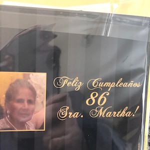 May include: A black and gold birthday card with the text "Feliz Cumplea&ntilde;os 86 Sra. Martha!" and a photo of a woman.