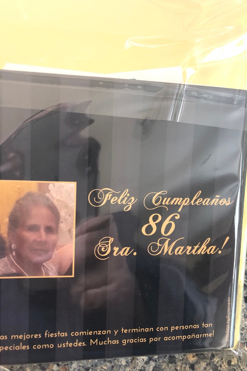 May include: A black and gold birthday card with the text "Feliz Cumplea&ntilde;os 86 Sra. Martha!" and a photo of a woman.