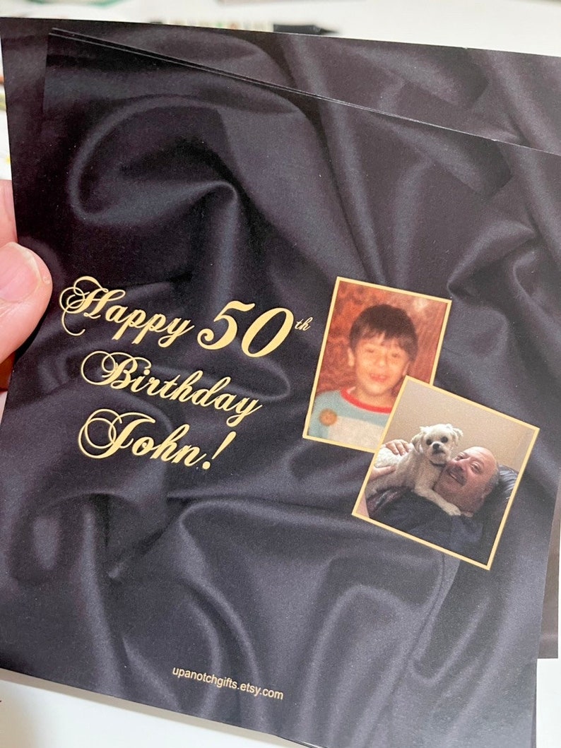 Puede incluir: Una tarjeta negra con una inscripci&oacute;n dorada que dice "Happy 50th Birthday John!" La tarjeta tiene dos fotos, una de un ni&ntilde;o peque&ntilde;o y otra de un hombre mayor con un perro.