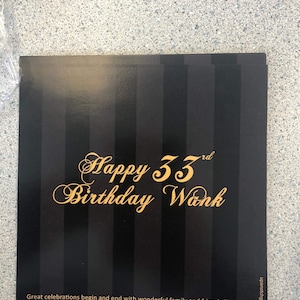 May include: Black and gold birthday card with a striped background. The card says "Happy 33rd Birthday Wank" and "Great celebrations begin and end with wonderful family and friends like you. Thanks so much for making this celebration the very best! Love, Wank".