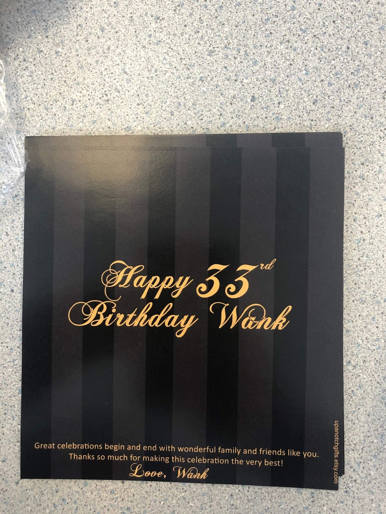 May include: Black and gold birthday card with a striped background. The card says "Happy 33rd Birthday Wank" and "Great celebrations begin and end with wonderful family and friends like you. Thanks so much for making this celebration the very best! Love, Wank".