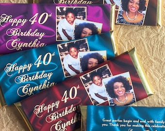 May include: Four chocolate bar wrappers with gold foil accents. Each wrapper features a different color background and a photo of a child and an adult. The text on the wrappers reads "Happy 40th Birthday Cynthia". The last wrapper is blue and has a message that reads "Great parties begin and end with family you. Thank you for making this celebration. Love, Cynthia."