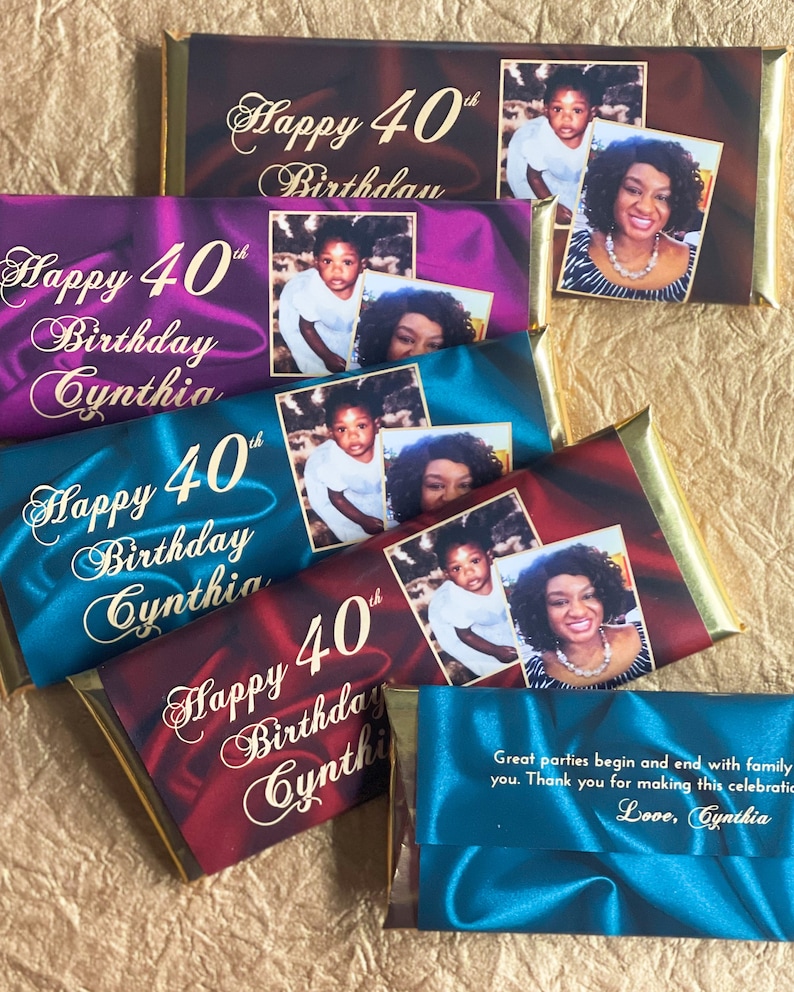 Puede incluir: Cuatro envoltorios de barras de chocolate con detalles de l&aacute;mina dorada. Cada envoltorio presenta un fondo de color diferente y una foto de un ni&ntilde;o y un adulto. El texto en los envoltorios dice "Happy 40th Birthday Cynthia". El &uacute;ltimo envoltorio es azul y tiene un mensaje que dice "Great parties begin and end with family you. Thank you for making this celebration. Love, Cynthia."