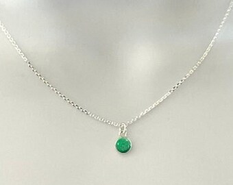 May include: A silver chain necklace with a small emerald green stone pendant. The necklace is 6mm wide and is made of sterling silver. The stone is called a "Heaven Stone" and is emerald green in color.