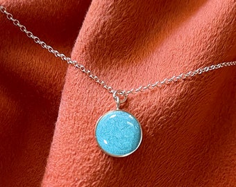 May include: A 14K gold filled 10mm round pendant necklace with a light blue aqua color. The necklace is on a silver chain and has a lobster clasp closure. Heaven Stones from MEMORIAL SILVER.