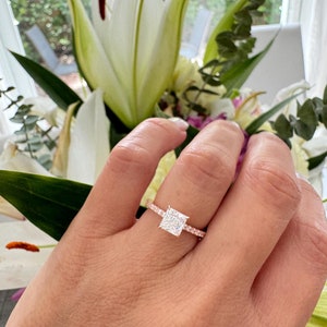 May include: A rose gold engagement ring with a square-shaped diamond and a pave band.