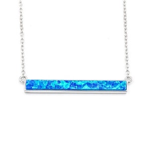 May include: A silver necklace with a blue opal bar pendant.