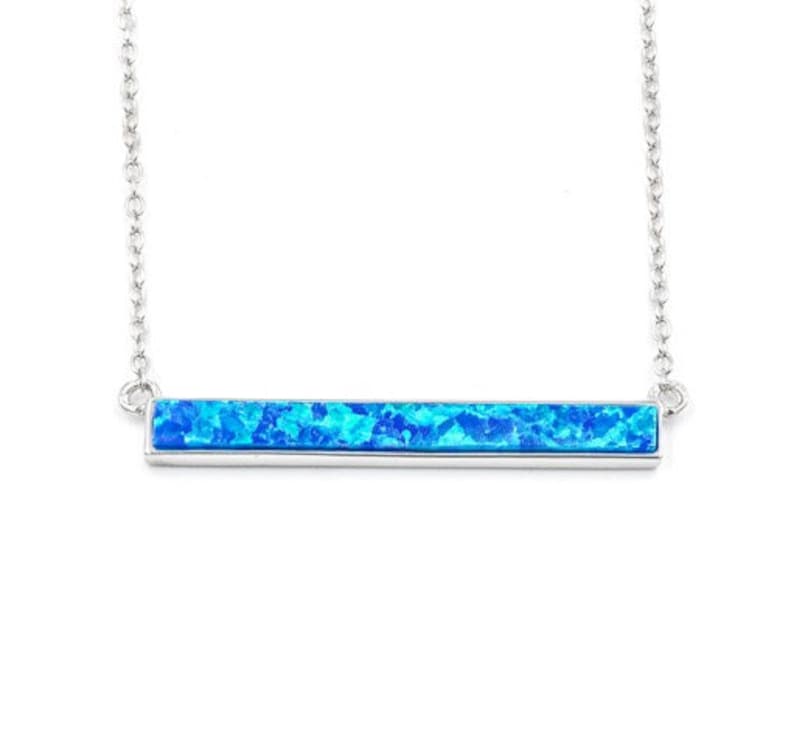 May include: A silver necklace with a blue opal bar pendant.