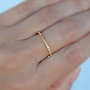 Anello dell'eternità in argento di alta qualità con zirconi cubici extra lucidi da 1 mm. Anello dell'eternità in zirconi cubici extra lucidi di alta qualità placcato in oro 18 carati. Fascia in zirconi cubici extra lucidi placcato in oro rosa 18 carati.