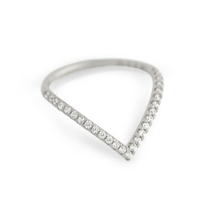 Op de afbeelding: Een zilveren ring met een V-vormig ontwerp bezet met kleine diamanten.