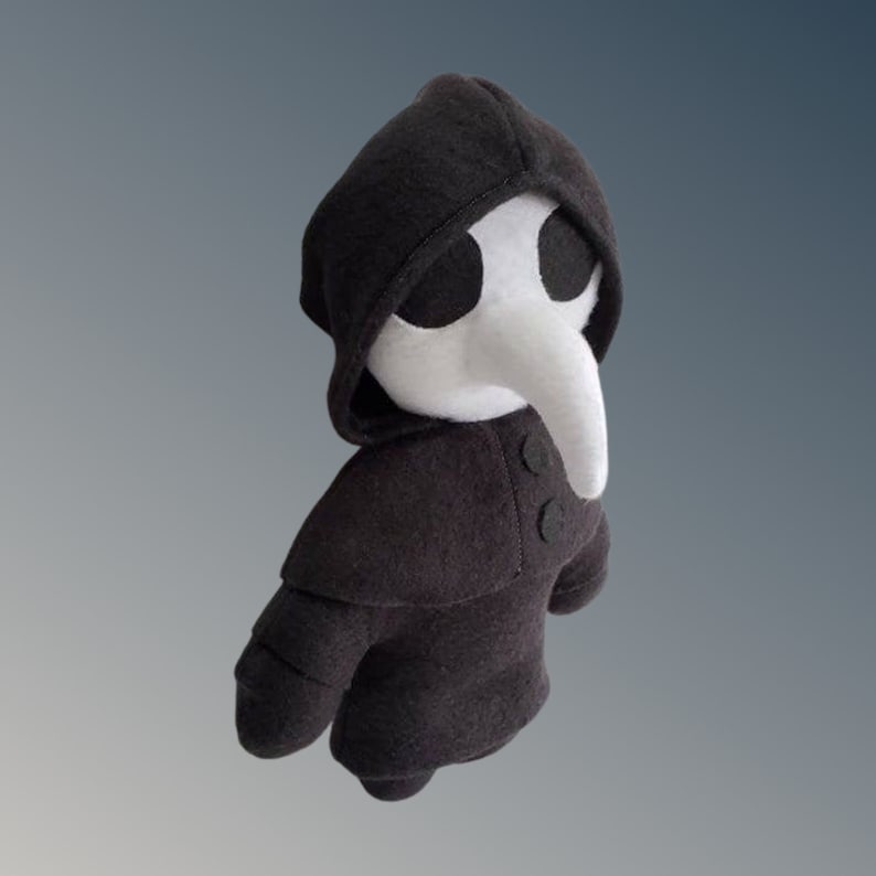 May include: A soft toy plague doctor, with a black hooded cloak and a white beak mask. The doll has two black buttons and is made of fabric. The background is a gradient of grey and white. A unique handmade item.